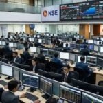 Investors monitoring stock market data on trading screens at an Indian stock exchange.
